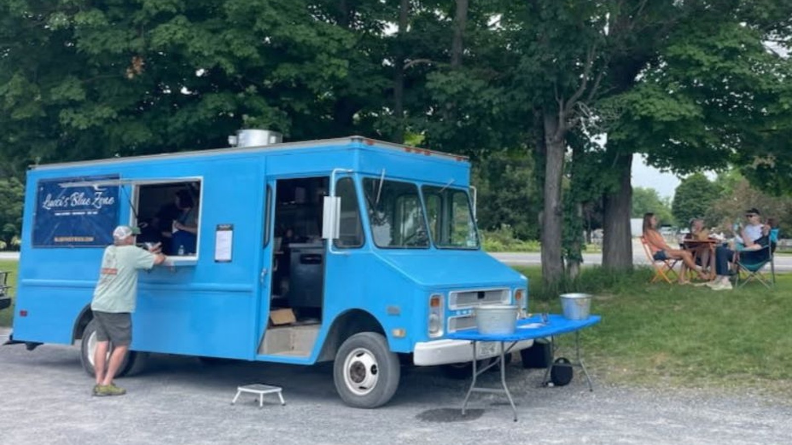 Lucci's Blue Zone truck at the Chatham Berry Farm, guests in chairs under the trees